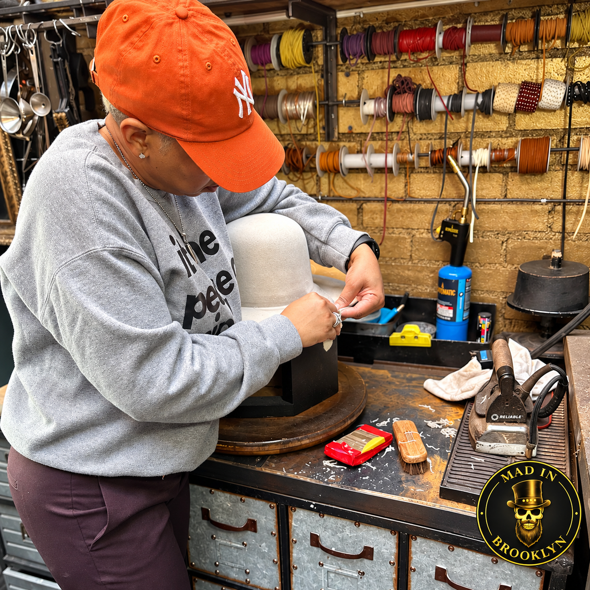 Student working on a hat block during a private Mad in Brooklyn hat-making workshop