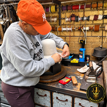 Student working on a hat block during a private Mad in Brooklyn hat-making workshop